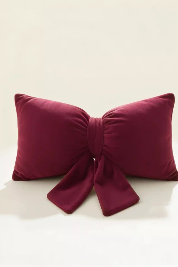 Pernă cu fundiță de Crăciun de la Needle and Thread – pernă din catifea bordo, certificată Oeko-Tex